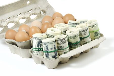 rolls of money with eggs in a grey recycled paper cartonの写真素材