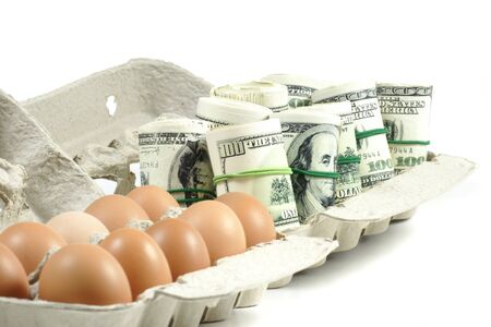 rolls of money with eggs in a grey recycled paper cartonの写真素材
