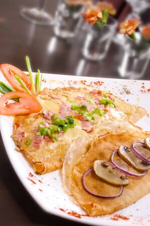 Pancakes with meat served with fresh tomato and mushrooms.の写真素材