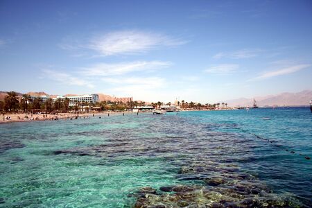 View of Eilat from the sea, with buildings bathers, and mountains in background.