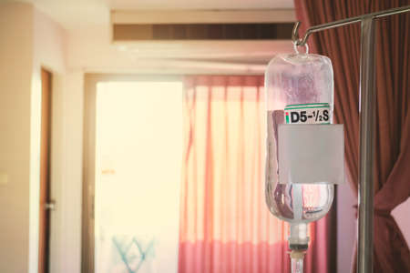 Saline infusion in the hospital. Saline container for patients who are hospitalized. The backdrop against the light of the sun.の写真素材