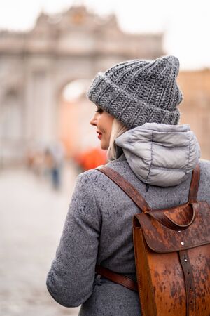 Blonde girl back in coat and hat on the street in the rain in Istanbul in the Parkの写真素材
