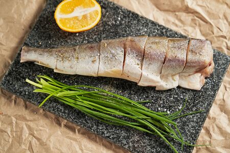 raw fish lemon and green onions on a black Board. cooking. cooking at home, recipes, dishes and menusの写真素材