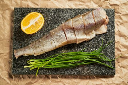 raw fish lemon and green onions on a black Board. cooking. cooking at home, recipes, dishes and menusの写真素材