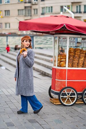 The girl with a donut on the street in Istanbul. The street food.の写真素材