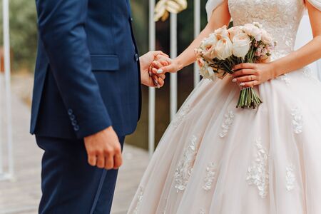 bouquet of roses for the bride in her hands. Traditional accessory