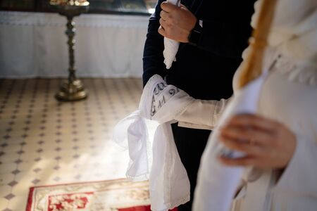 hands of the bride and groom associated with a towel on the wedding in the Church. without entities.