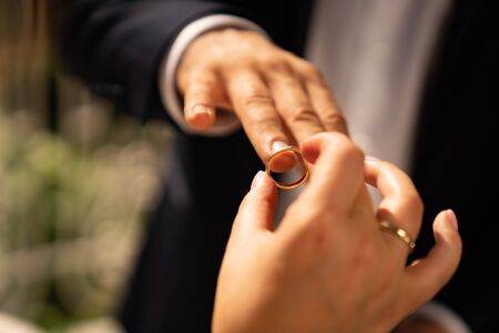 the groom and bride put on each other rings. close-up. wedding traditions. weddingの写真素材