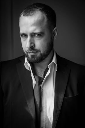 portrait of a man with beard in a suit and tie over the shoulder. black-whiteの写真素材