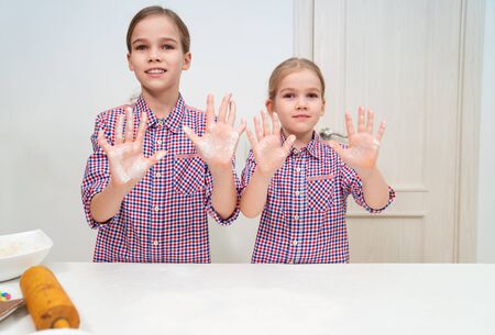 sisters cook together and play with flour. home cooking.の写真素材