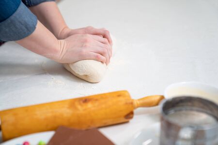 women hands knead yeast dough for pie or pizza. cook at home.