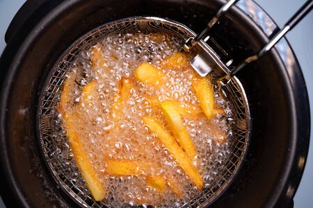 cook French fries. oil boiling in a deep fryer at home. top view. close up.