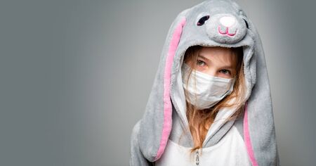 teen girl in kigurumi rabbit in a medical mask at home in quarantine. close up. copy space