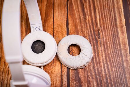 need a replacement embouchures on old white earbud. repair accessories.wooden backgroundの写真素材