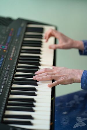 woman hands black and white piano keys synth. close-up. without people.