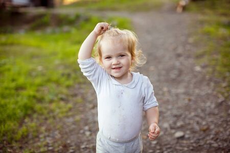 dirty and shaggy little girl at a campground in the mountains. family vacation camping. villageの写真素材