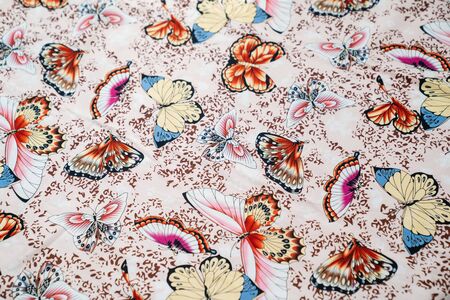 light fabric background colorful butterflies. pattern and ornament.