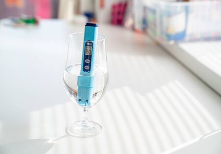 TDS meter in a glass to determine the quality of drinking water. purification and filtering...