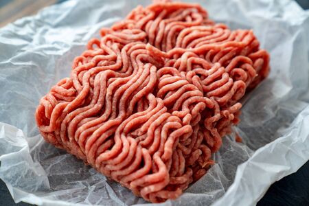 the minced meat on the cooking paper and stone tray. prefabricated patties.の写真素材