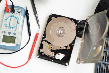 open Computer Hard Drive on white background with screwdriver set. Hands in black gloves. master of repair.の写真素材