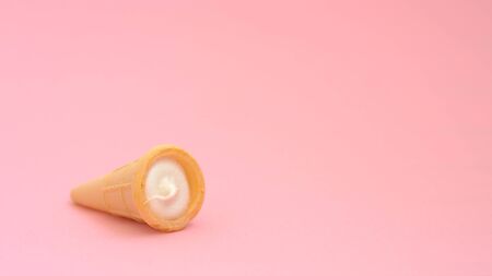 Vanilla cream in wafer cup. Vanilla ice cream cone on pink color background. Candy bar and cake pops. Holiday treats. Sweet tooth. Candy shop.の写真素材
