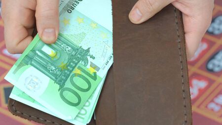 hands counts cash money female hands (american dollars, euros) on the red table gaming casino...