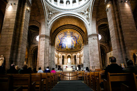 14.03.2016 Paris, France. Catholic Cathedral inside. parishioners sit on the benches during the service.のeditorial素材