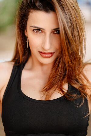 the girl athlete in sports apparel in the Park outdoors. fitness training outdoors. strength exercises, cardio workout.の写真素材