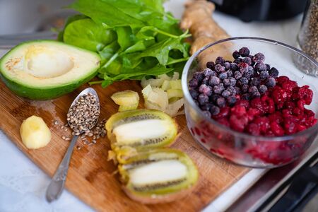 ingredients for smoothies - kiwi, avocado, spinach, Chia, raspberries, blueberries and ginger on a wooden Board. cooking healthy food. sports nutrition.の写真素材