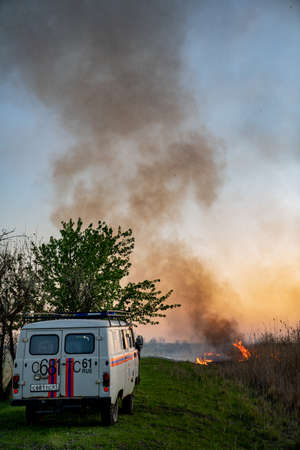 01.05.2020 Russia Rostov-on-don, burns dry grass, in the sky, the smoke and soot. fire extinguish truck emergency rescue, fire. the environmental problem.のeditorial素材