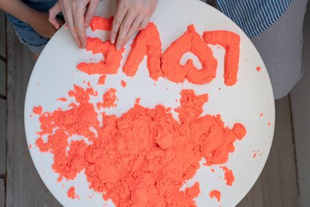hand molded of red kinetic sand the word love. the development of fine motor skills. educational gamesの写真素材