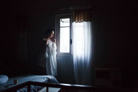 Provence. Girl in the morning standing at the window in the bedroom.の写真素材
