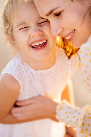 mother and daughter together on the beach. vacation with children. family relationships and understanding parents and children.の写真素材