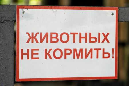 A sign at the zoo with the inscription in Russian - do not feed the animals. Harmful food for animals, penalties for the visitors.の写真素材