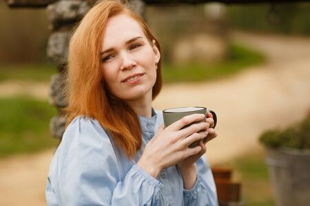 a girl drinks tea in the morning in the yard near the stone well of a village house in Provence. journey through the South of France.の写真素材