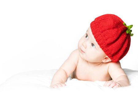 cute baby girl in a red knitted cap. the concept of skin care of the newborn child.の写真素材