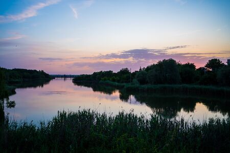 beautiful evening landscape. sunset on the river. calm water in the pond.