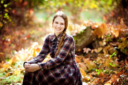 the woman in the plaid dress in the autumn forest. nature walks.の写真素材