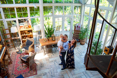 the view from the top. family with a small daughter playing in a country house with panoramic windows.の写真素材