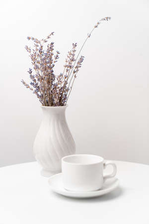 white tea Cup and a vase with lavender on a white table. table setting for tea.の写真素材