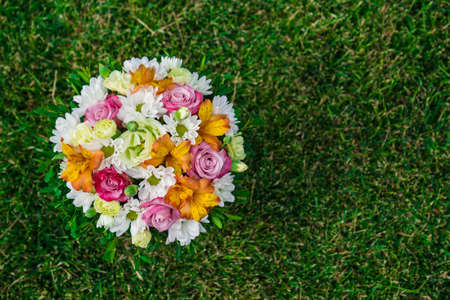 a bouquet of colorful flowers on a green lawn. top view. place for text.の写真素材