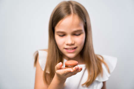 macaron made from natural ingredients in the foreground, on the background holding in her hands of a...