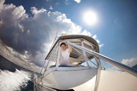 a man in a white clothes, traveling on a yacht in the open sea.の写真素材