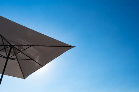 bottom view. beach umbrella against a blue cloudless sky. sun protection on the beach.の写真素材