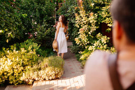 a professional photographer takes a picture of a woman expecting a baby in the backyard garden. it is a tradition to take photos as a souvenir. pregnancy photo shootの写真素材