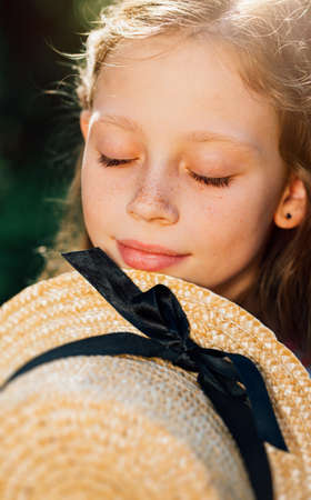 close up. beautiful girl with freckles with a straw hat. clean and healthy skin. happy childhood....