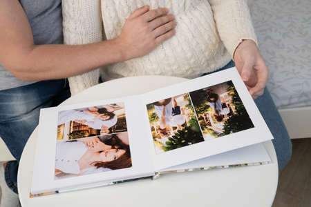 close up. a couple waiting for the baby flips through a photobook from a family pregnancy photo shoot. beautiful and convenient storage of photos. memory of an important period.の写真素材