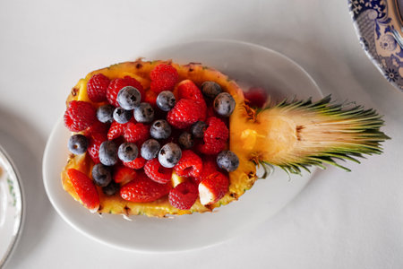 pineapple stuffed with raspberry berries, strawberries, blueberries.の写真素材