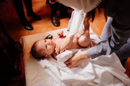 mom dress their child on a table in the Church. the ordinance of baptism.