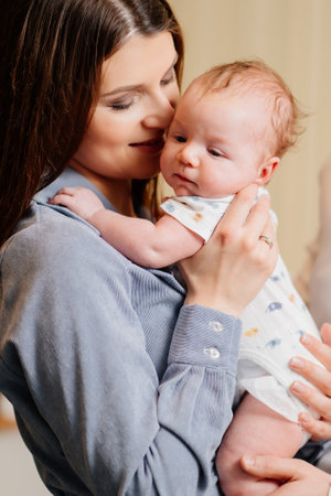 Mom gently holds on her kid in arm. long-awaited baby. Mothers Day.の写真素材